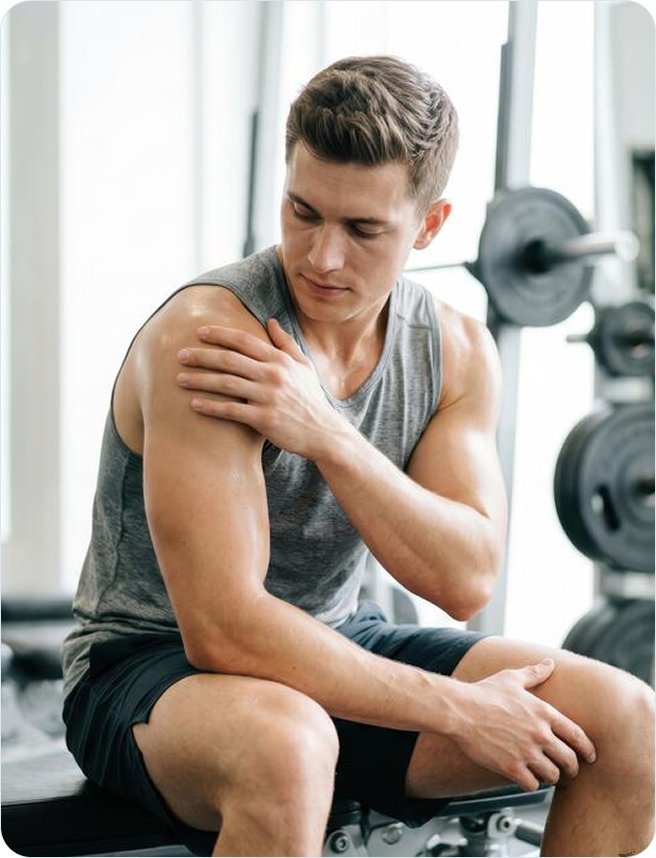 Man holding his sore shoulder at the gym