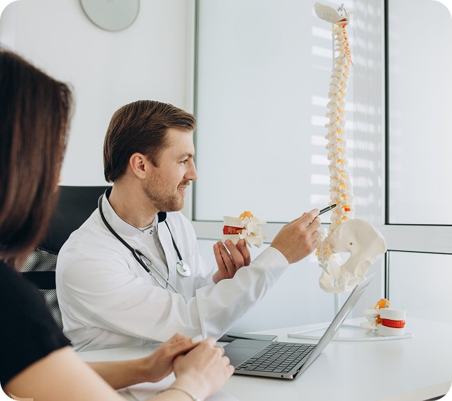 Chiropractor explaining a spine model to a patient